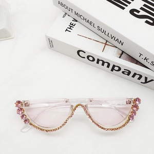 Close-up of pink rimless crescent sunglasses with sparkling rhinestones and clear lenses