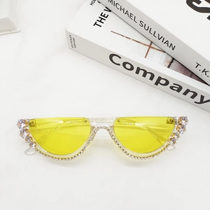 Detailed view of yellow half-rim sunglasses with rhinestones and vintage gemstones
