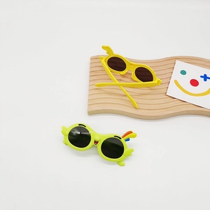 Detailed top view of cartoon parrot wings sunglasses in yellow and green for kids