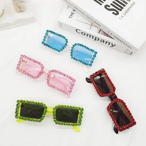 Retro square rhinestone sunglasses in multiple colors displayed on white fabric
