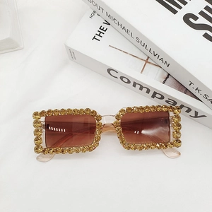 Macro detail of rectangle sunglasses with gold rhinestones and brown gradient lenses