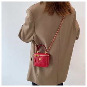 Vista trasera de una modelo con el mini bolso cubo de cuero acolchado rojo con cadena