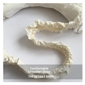 Detail of comfortable wide pleated strap on a beige cloud-shaped crossbody bag