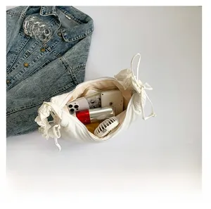 Top view of spacious white dumpling bag interior filled with essentials and cosmetics