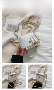 Detailed view of white quilted cube bag with gold camellia clasp and chain strap
