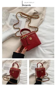 Detail view of wine red quilted mini box bag with gold floral hardware and chain strap
