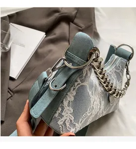 Detail of light blue lace shoulder bag featuring large silver metal ring and chain