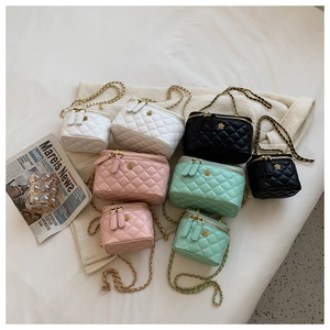 Close-up of quilted chain crossbody bags in white, black, pink, and mint green colors