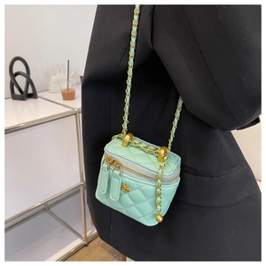 Detail van mintgroene gewatteerde vanity bag met bloemige gouden ketting en ritssluiting