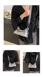Lace chain bag detail showing light blue fabric and white floral patterns with silver strap