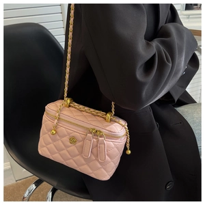 Roze gewatteerde crossbodytas met gouden ketting gedragen op een zwarte blazer outfit