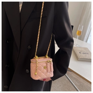 Pink quilted bucket bag with golden camellia flower hardware and chain strap detail