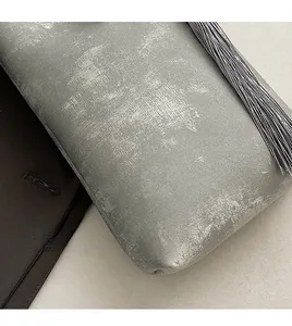 Gros plan sur tissu texturé gris avec détails de pompons élégants et tissage doux