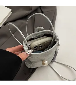 Vue intérieure d'un mini sac seau argenté contenant un smartphone et fermoir aimanté
