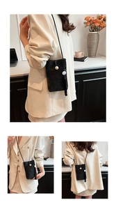 Détail du petit sac bandoulière noir vintage avec motifs sombres et pompon