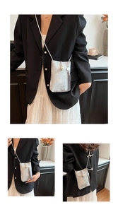 Sac bandoulière argenté pour téléphone avec perle et pompon dans une scène lifestyle chic