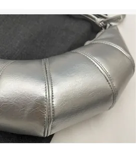 Detailed close-up of metallic silver crescent bag showing soft textured faux leather