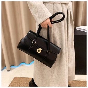 Nahaufnahme der schwarzen Vintage-Unterarmtasche mit elegantem goldenem Rundverschluss