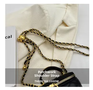 Macro detail of quilted black leather bag with gold chain strap and adjustable ball