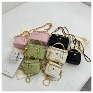 Detail view of quilted leather mini bags with gold camellia logo and chain straps