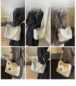 Dettaglio della borsa a secchiello in seta ricamata con nappine e jacquard floreale