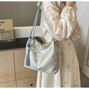 Dettaglio della borsa jacquard in stile cinese con nappina di seta e perla decorativa
