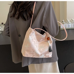 Dettaglio borsa ricamata in jacquard rosa con nappa sfumata e motivo a montagna cinese