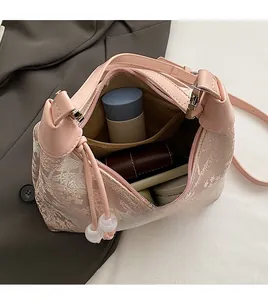 Detail view of pink Chinese style handbag interior with large capacity and zip pocket