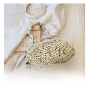 Detail of woven straw handbag with vintage marble-textured bead handle on white fabric