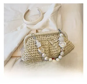 Detail of hand-woven beige straw bag featuring marble-textured acrylic bead handles