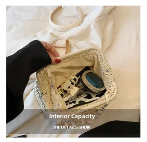 Top view of woven beige handbag showing inner storage capacity with pearl handle
