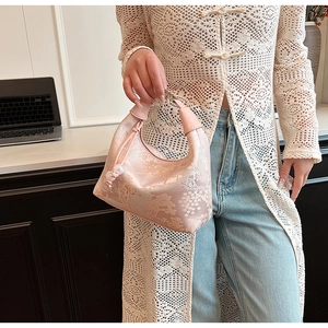 Detail of pink jacquard handbag with traditional Chinese floral patterns and leather handle