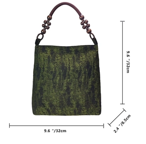 Detail view of moss green tote bag with ethnic embroidery and wooden beads decor