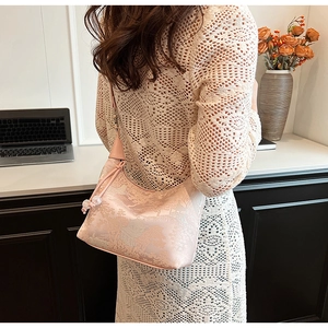 Detail of pink floral jacquard handbag with silk texture and elegant beaded pendant