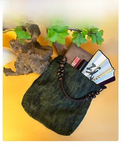 Internal capacity of green moss tote bag showing wood bead handle and essentials