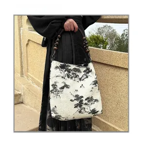 Detail of wooden bead handle and ink landscape print on canvas tote bag