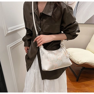 Detailed embroidery on white New Chinese style handbag with elegant floral window patterns