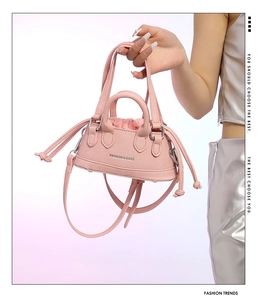 Nahaufnahme der rosa PU-Lederhandtasche mit Kordelzug-Innentasche und modischer Aufschrift