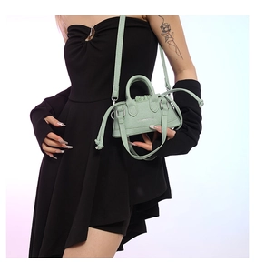 Nahaufnahme der minzgrünen Mini-Handtasche aus PU-Leder, getragen zum schwarzen Kleid