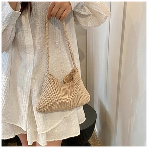 Detail of beige hand-knitted tote bag showing dense texture and woven handle