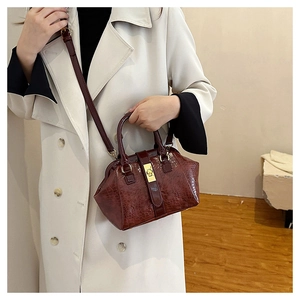 Elegante burgunderrote Kroko-Muster Ledertasche mit Verschluss und verstellbarem Schultergurt.