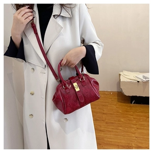 Dunkelrot Krokodil Muster Handtasche Detailansicht zeigt eleganten Retro Stil Metall Schloss.