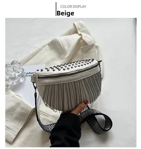 Detail of beige crescent bag with silver studs, fringe, and geometric strap