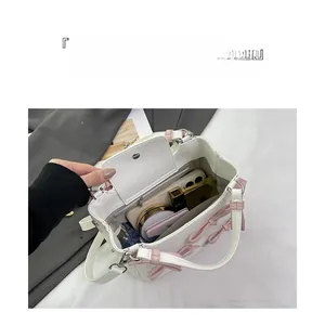 Interior view of small white handbag showing main compartment for mobile and cosmetics
