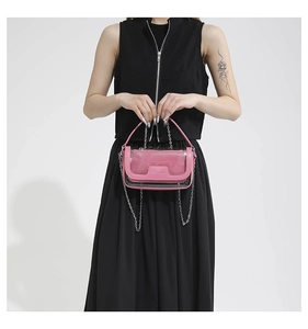 Detail der rosa transparenten Jelly-Tasche mit Metalllogo und Kette auf schwarzem Kleid