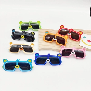 Détail de huit paires de lunettes de soleil ours colorées pour enfants sur socle en bois