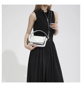 Détail d'un sac à main blanc brillant avec coutures transparentes et bandoulière chaîne