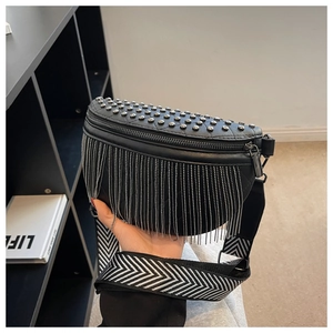 Close-up of black leather crossbody bag featuring silver rivets and metal fringe chains