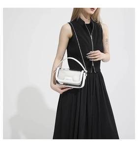 Détail du sac à chaîne en PVC blanc semi-transparent avec finitions métalliques sur modèle