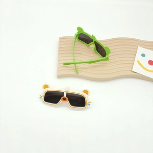 Détail de lunettes de soleil polarisées pour enfants en forme d'ours vert et crème